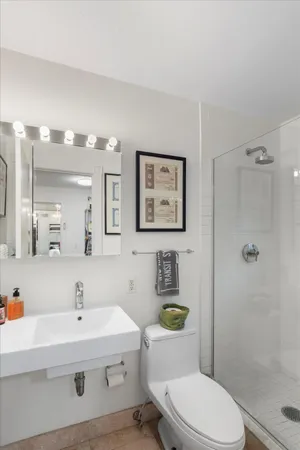 a bathroom with a sink a toilet and shower