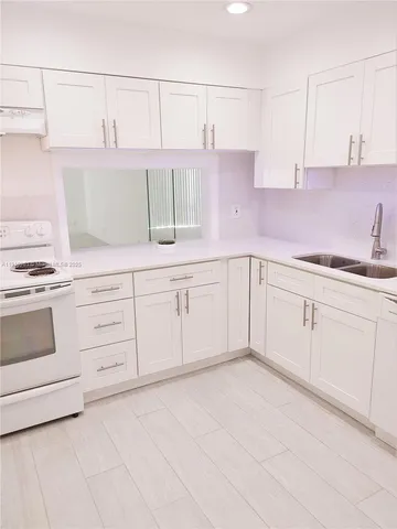 a kitchen with white cabinets and white appliances