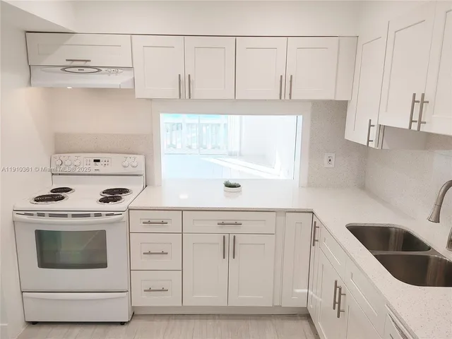 a kitchen with white cabinets and white appliances
