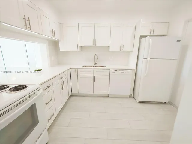 a kitchen with granite countertop white cabinets white stainless steel appliances with a sink and dishwasher