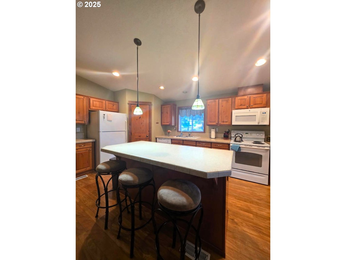190 North Sentosa Lake Road Tygh Valley, OR 97063 - Photo 19 of 45 a kitchen with stainless steel appliances kitchen island a table chairs in it and wooden floors