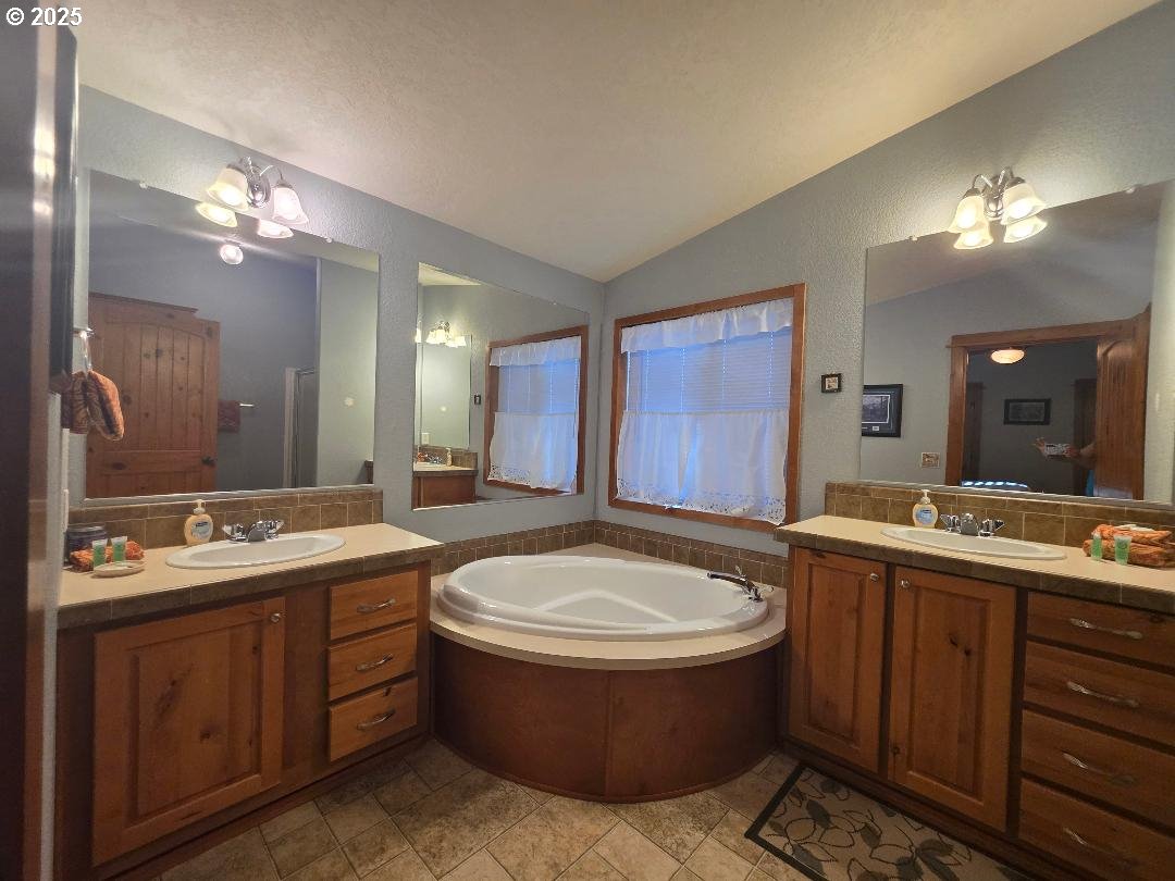 190 North Sentosa Lake Road Tygh Valley, OR 97063 - Photo 38 of 45 a bathroom with a tub a double vanity sink and a mirror