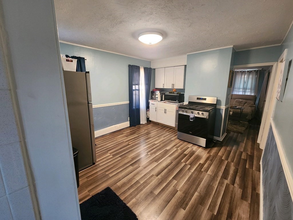 28 Frederick Street New Bedford, MA 02744 - Photo 19 of 29 a kitchen with a refrigerator stove and wooden floor