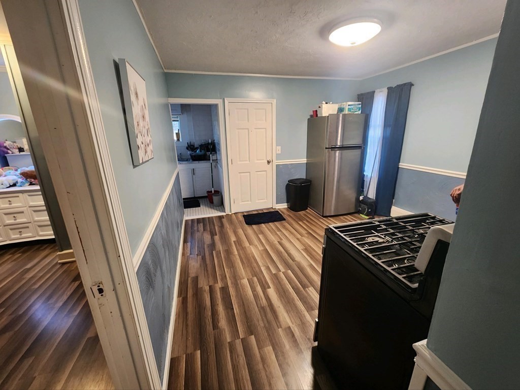 28 Frederick Street New Bedford, MA 02744 - Photo 20 of 29 a kitchen with refrigerator a stove and wooden floor