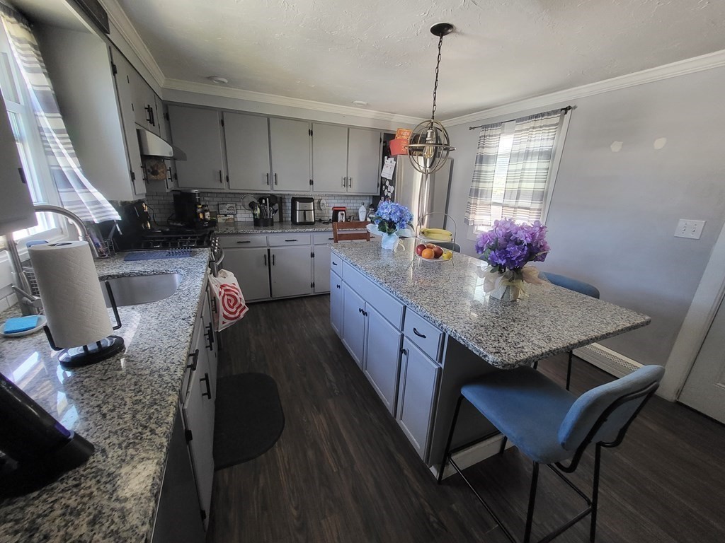 28 Frederick Street New Bedford, MA 02744 - Photo 9 of 29 a kitchen with sink a refrigerator and chairs