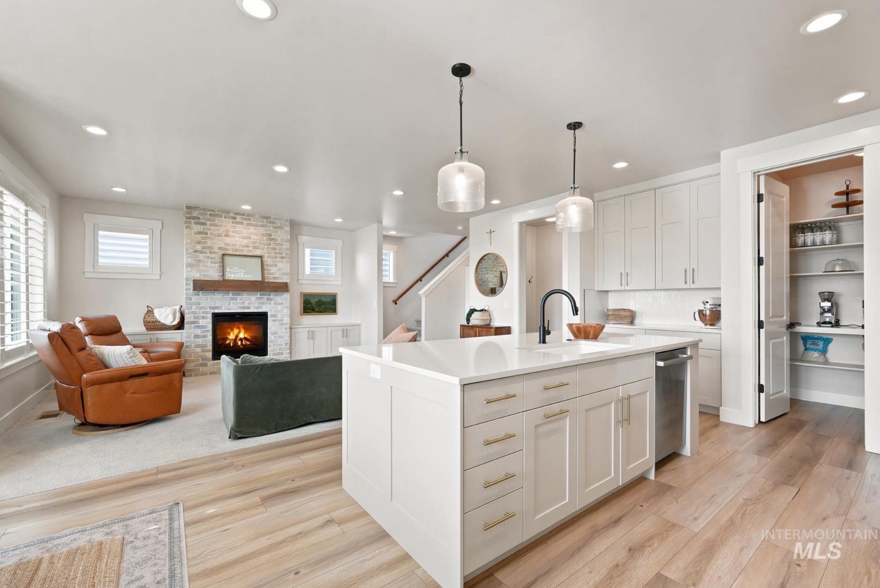 6933 South Zenith Avenue Meridian, ID 83642 - Photo 9 of 34 Open-concept kitchen featuring an oversized island with an undermount sink, pendant lighting, and stainless steel dishwasher