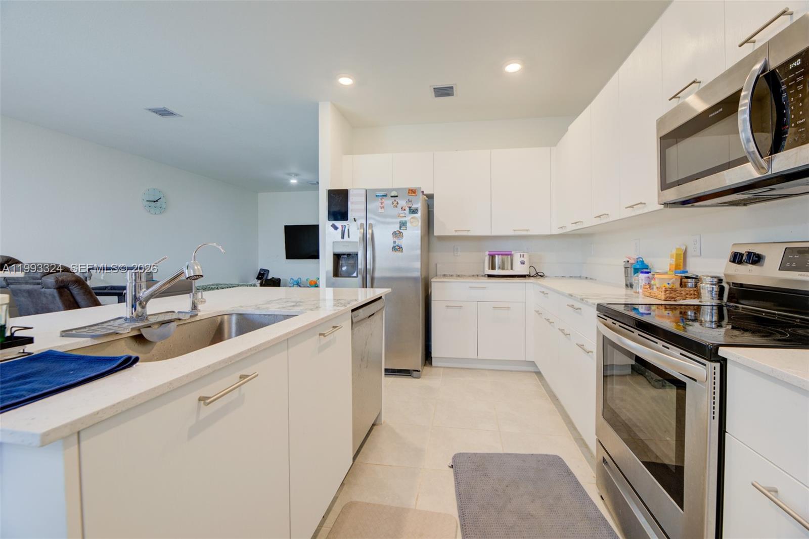 12604 Northwest 23rd Place Miami, FL 33167 - Photo 16 of 39 a kitchen with cabinets and white appliances