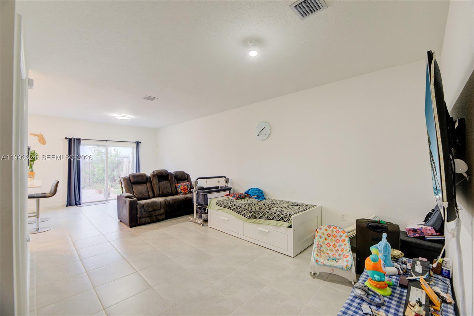 12604 Northwest 23rd Place Miami, FL 33167 - Photo 6 of 39 a living room with furniture and a flat screen tv