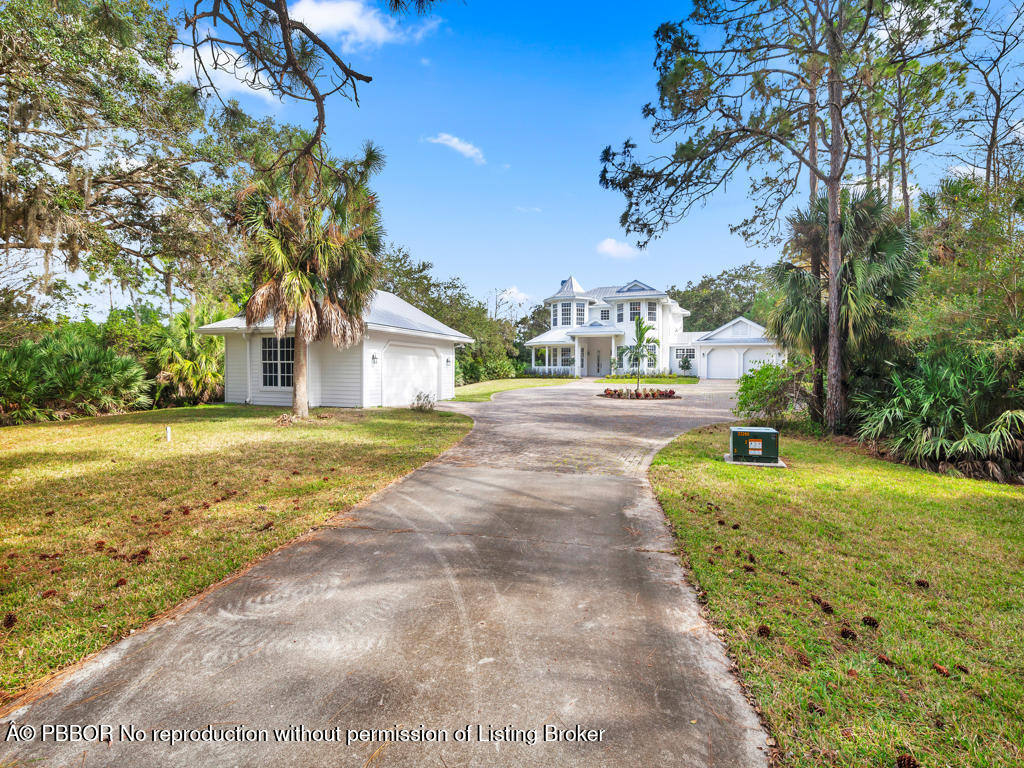 1001 Southeast Ranch Road Northeast Jupiter, FL 33478 - Photo 5 of 32 a house with trees in the background
