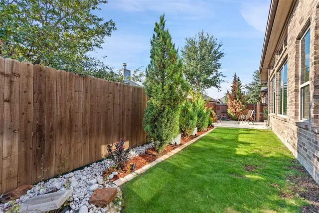 a view of a backyard with potted plants and wooden fence