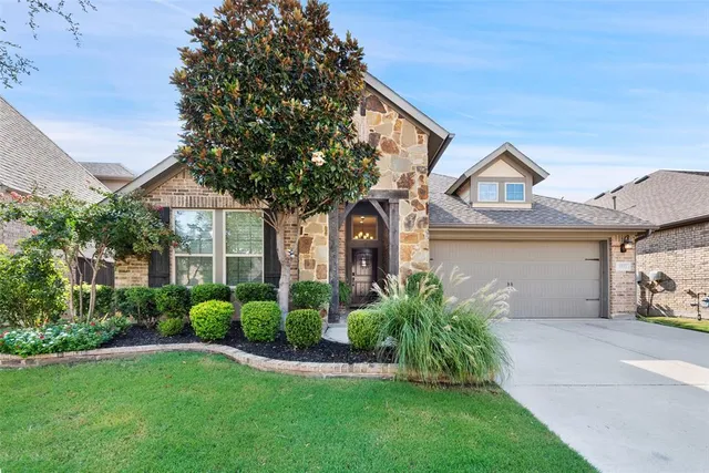 a front view of a house with a garden and plants