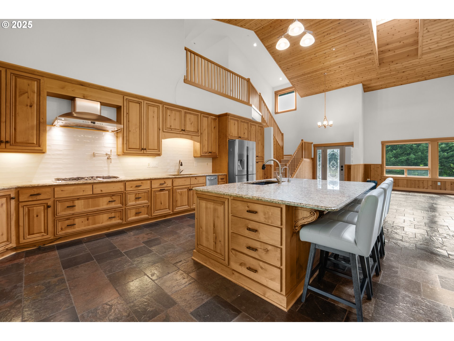 37769 Sunset Highway Seaside, OR 97138 - Photo 9 of 48 a kitchen with stainless steel appliances kitchen island granite countertop a table chairs and a sink