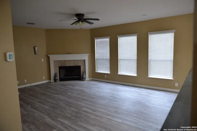 a view of an empty room with a fireplace and a window