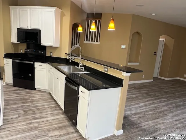 a kitchen with stainless steel appliances granite countertop a stove a sink and a microwave