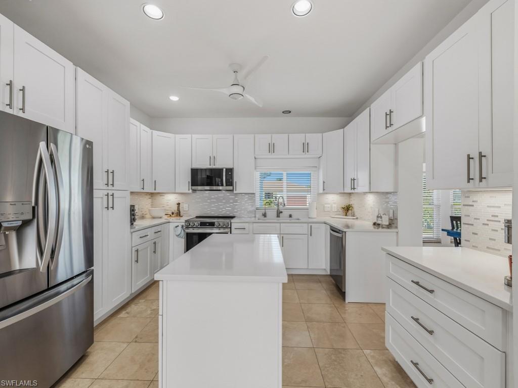 396 Conners Avenue Naples, FL 34108 - Photo 12 of 27 a kitchen with cabinets stainless steel appliances and a counter space