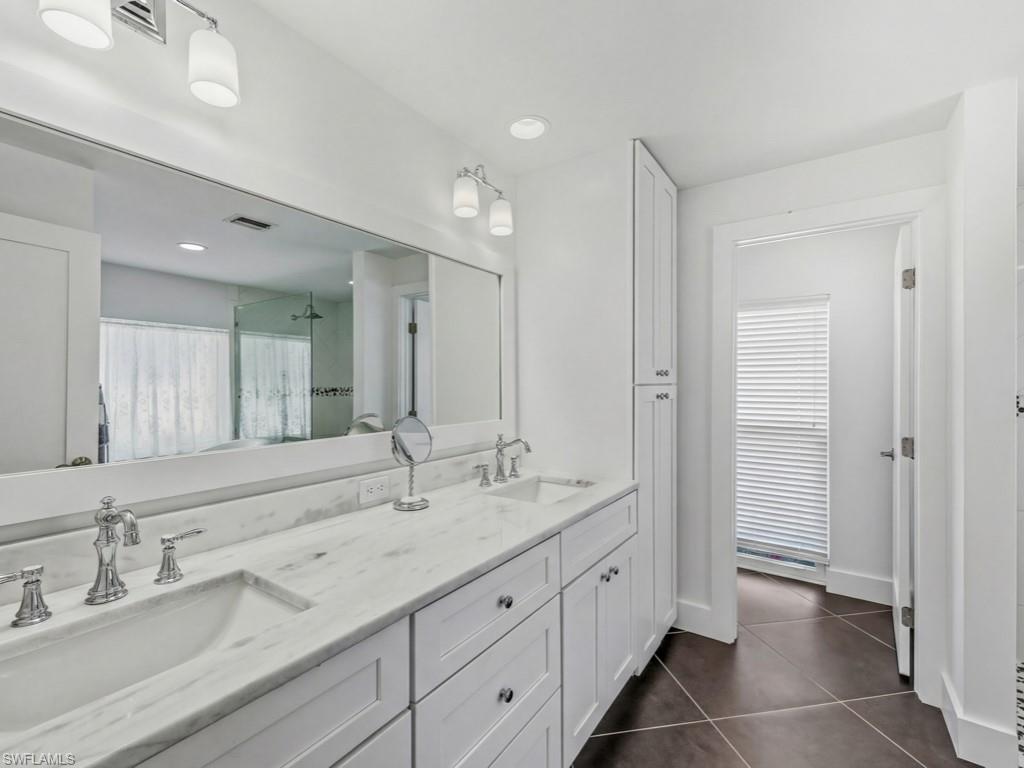 396 Conners Avenue Naples, FL 34108 - Photo 18 of 27 a spacious bathroom with double sink and a mirror