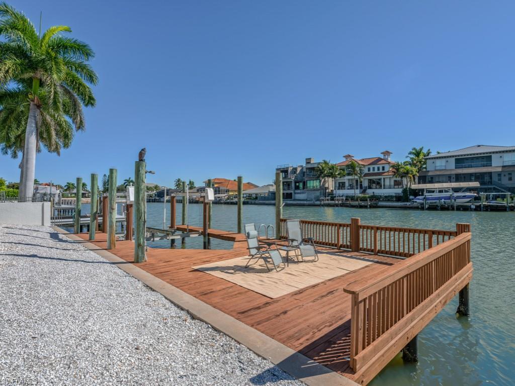 396 Conners Avenue Naples, FL 34108 - Photo 25 of 27 a view of a terrace with a table and chairs