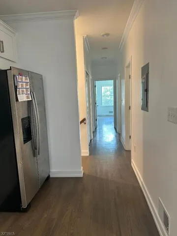 a view of hallway with stairs and wooden floor