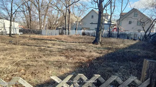 a backyard of a house with large trees and outdoor seating