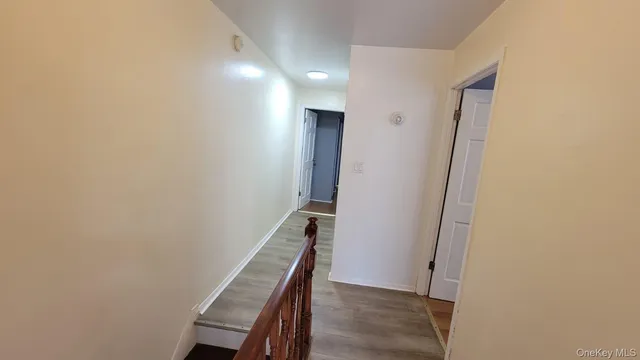 a view of a hallway with wooden floor and entryway