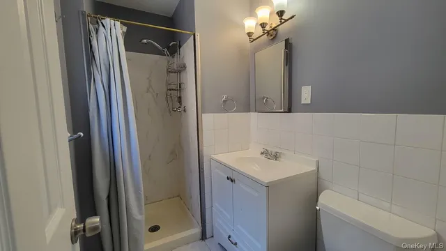 a bathroom with a shower a mirror and a sink