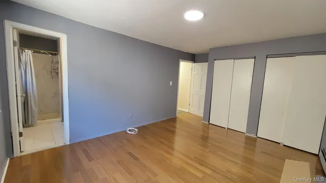 an empty room with wooden floor and sliding door