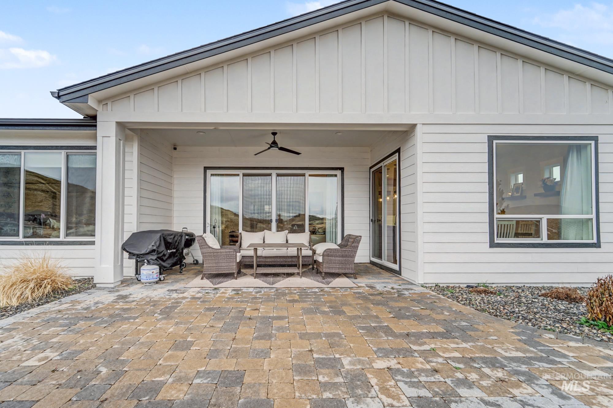 18357 North Burnt Car Way Boise, ID 83714 - Photo 34 of 48 Back of house with ceiling fan, board and batten siding, an outdoor living space, and a patio