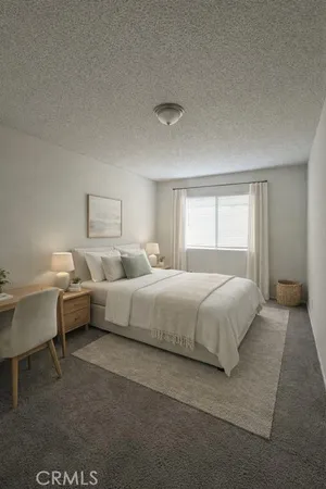 a spacious bedroom with a bed and a table chair