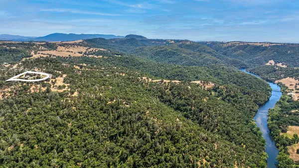 a living room with stainless steel appliances furniture a rug and a window