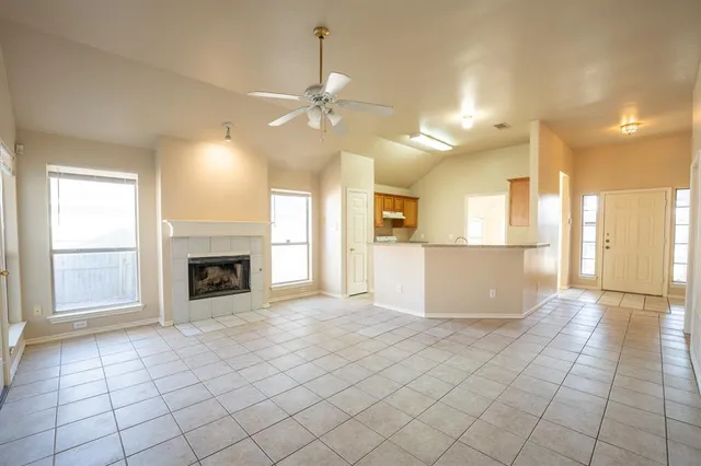 a view of a livingroom with a fireplace a chandelier a windows a fireplace and chandelier