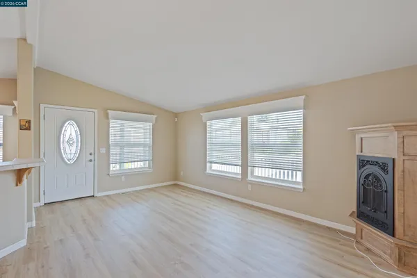 a view of a livingroom with a fireplace window and wooden floor