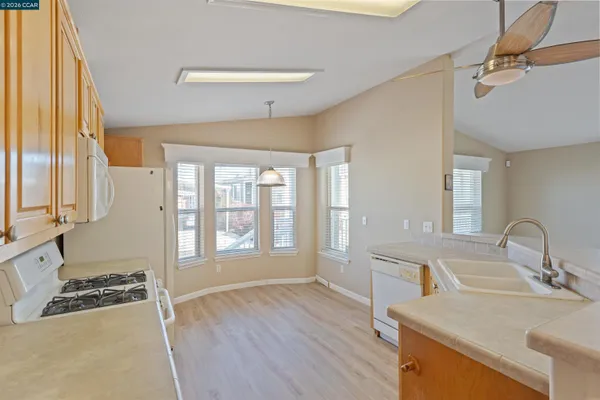 a kitchen with a sink wooden floor and a large window