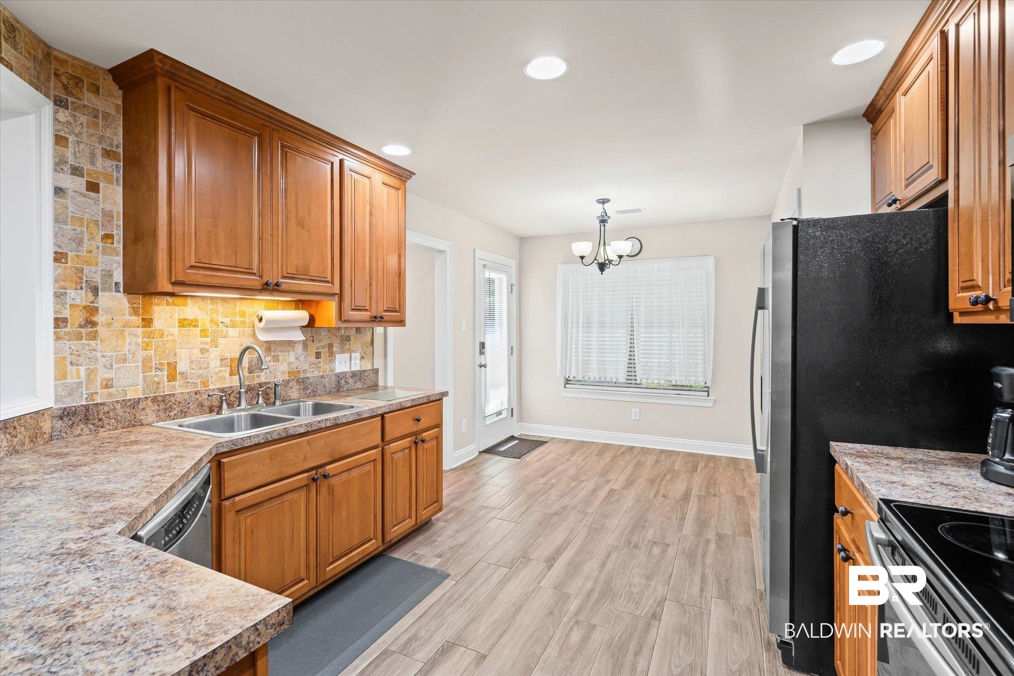641 South Pine Street Foley, AL 36535 - Photo 15 of 22 Kitchen featuring tasteful backsplash, hanging light fixtures, brown cabinetry, light wood-style floors, and recessed lighting