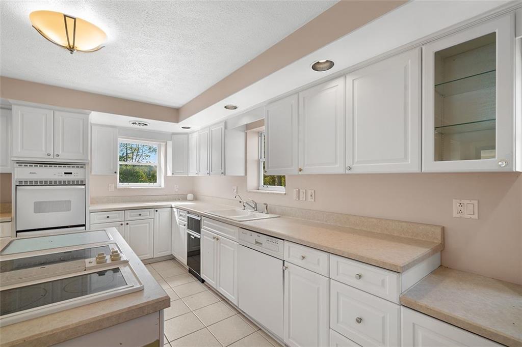 2121 Magnolia Street Pittsburgh, PA 15212 - Photo 12 of 36 a kitchen with a sink dishwasher and white cabinets with wooden floor