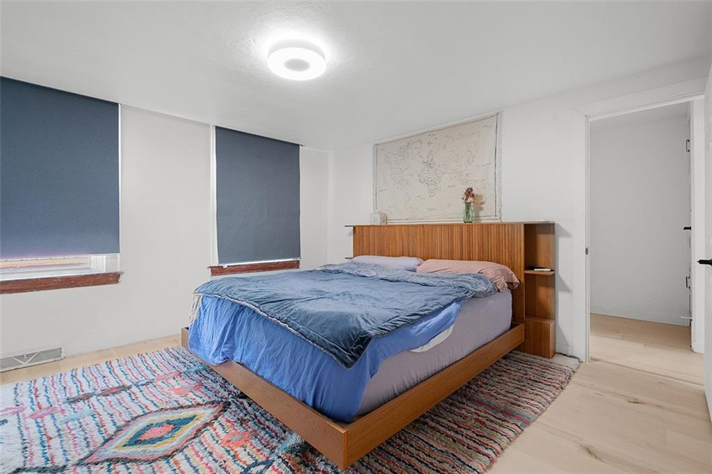 2121 Magnolia Street Pittsburgh, PA 15212 - Photo 20 of 36 a bedroom with a bed and wooden floor