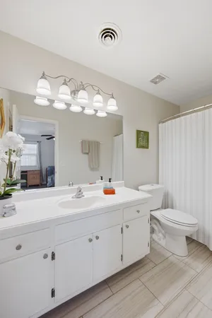a view of a double vanity sink mirror and toilet