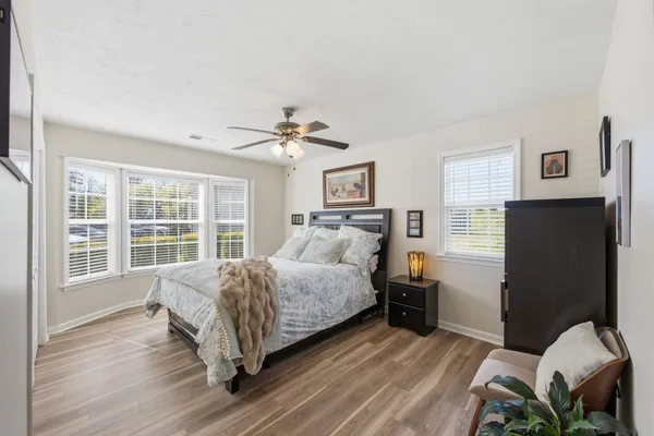 a spacious bedroom with a bed and wooden floor
