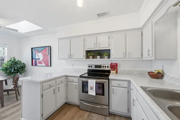 a kitchen with white cabinets and white appliances