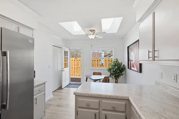 a view of a kitchen with kitchen island a counter top space a sink stainless steel appliances and cabinets
