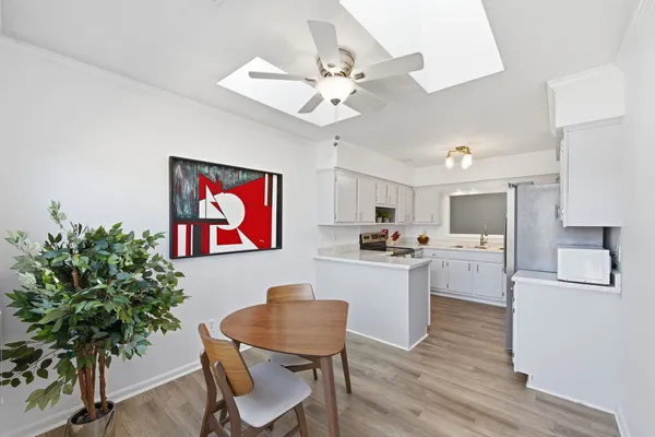 a living room with furniture kitchen view and a potted plant