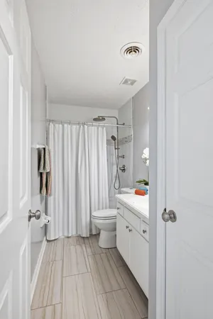 a bathroom with a sink a toilet and shower