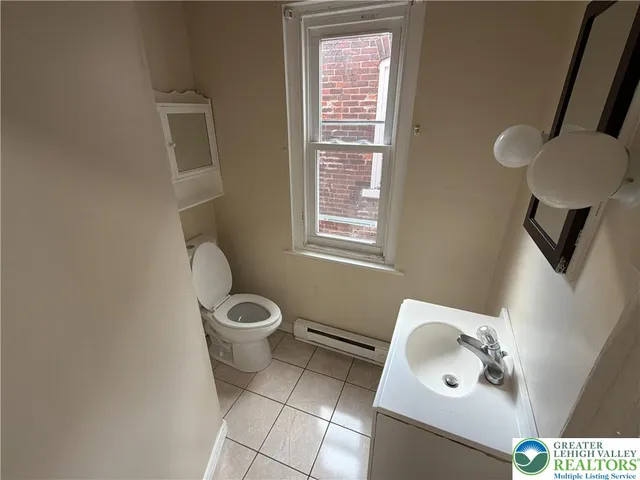 a bathroom with a toilet a sink and a window
