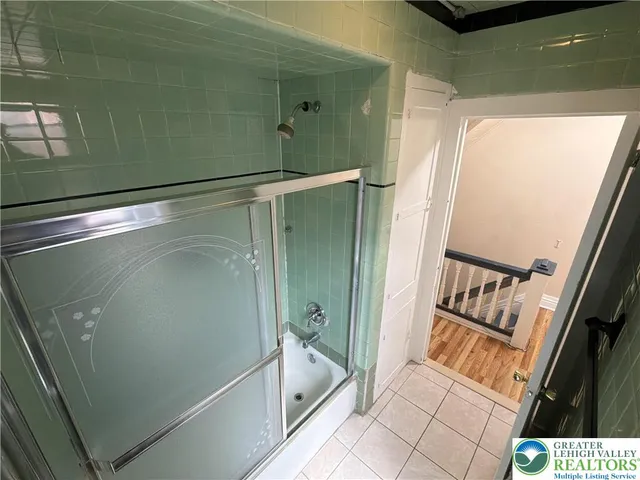 a bathroom with a glass door shower and a sink