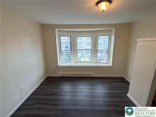 a view of room with window and wooden floor