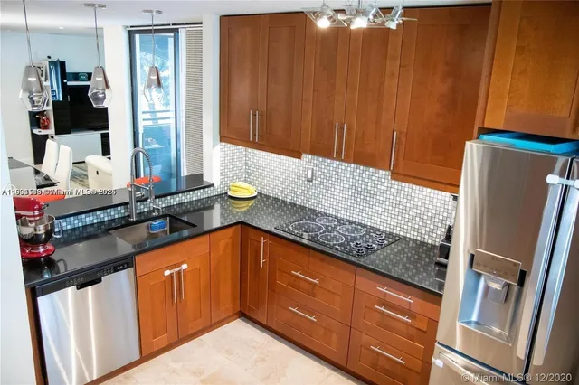 a kitchen with stainless steel appliances granite countertop a refrigerator and a stove