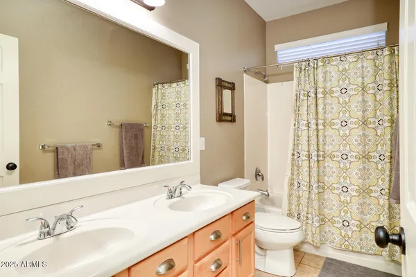 a bathroom with double vanity sink toilet a shower and a large mirror