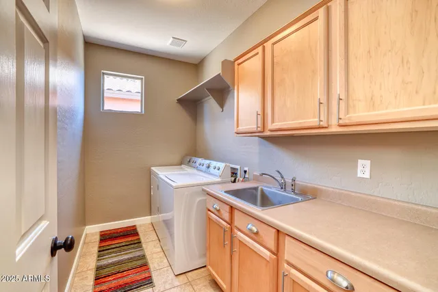 a utility room with sink dryer and washer