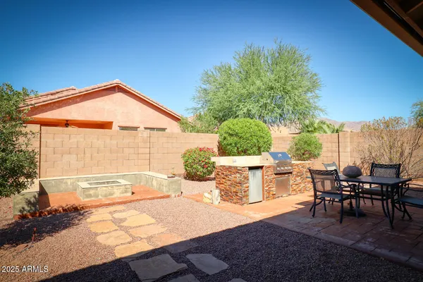 a backyard of a house with table and chairs