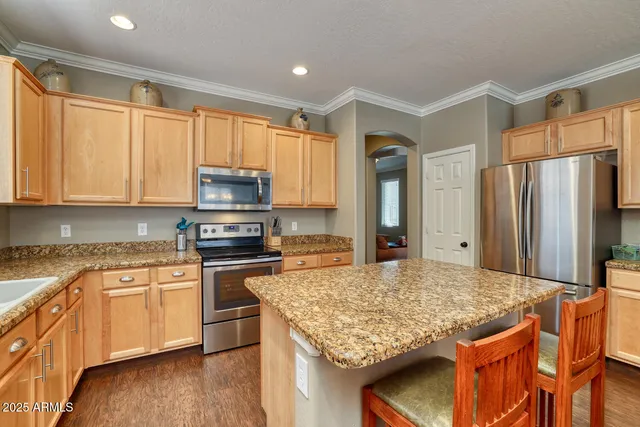 a kitchen with stainless steel appliances granite countertop a stove top oven a sink and a refrigerator