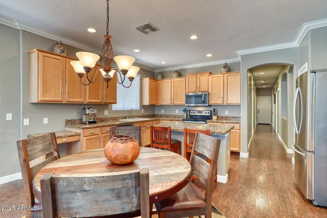 a kitchen with stainless steel appliances granite countertop a stove a sink a refrigerator and island